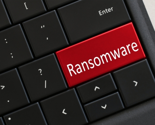 Imagem de um teclado de computador preto com uma tecla vermelha escrita ransomware