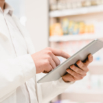 gestão de estoque de itens consignados- Imagem de uma pessoa mexendo no tablet e ao fundo um estoque de farmácia ou hospital