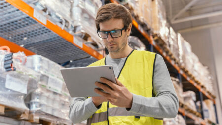 homem com tablet na mão em um estoque de uma distribuidora de opme